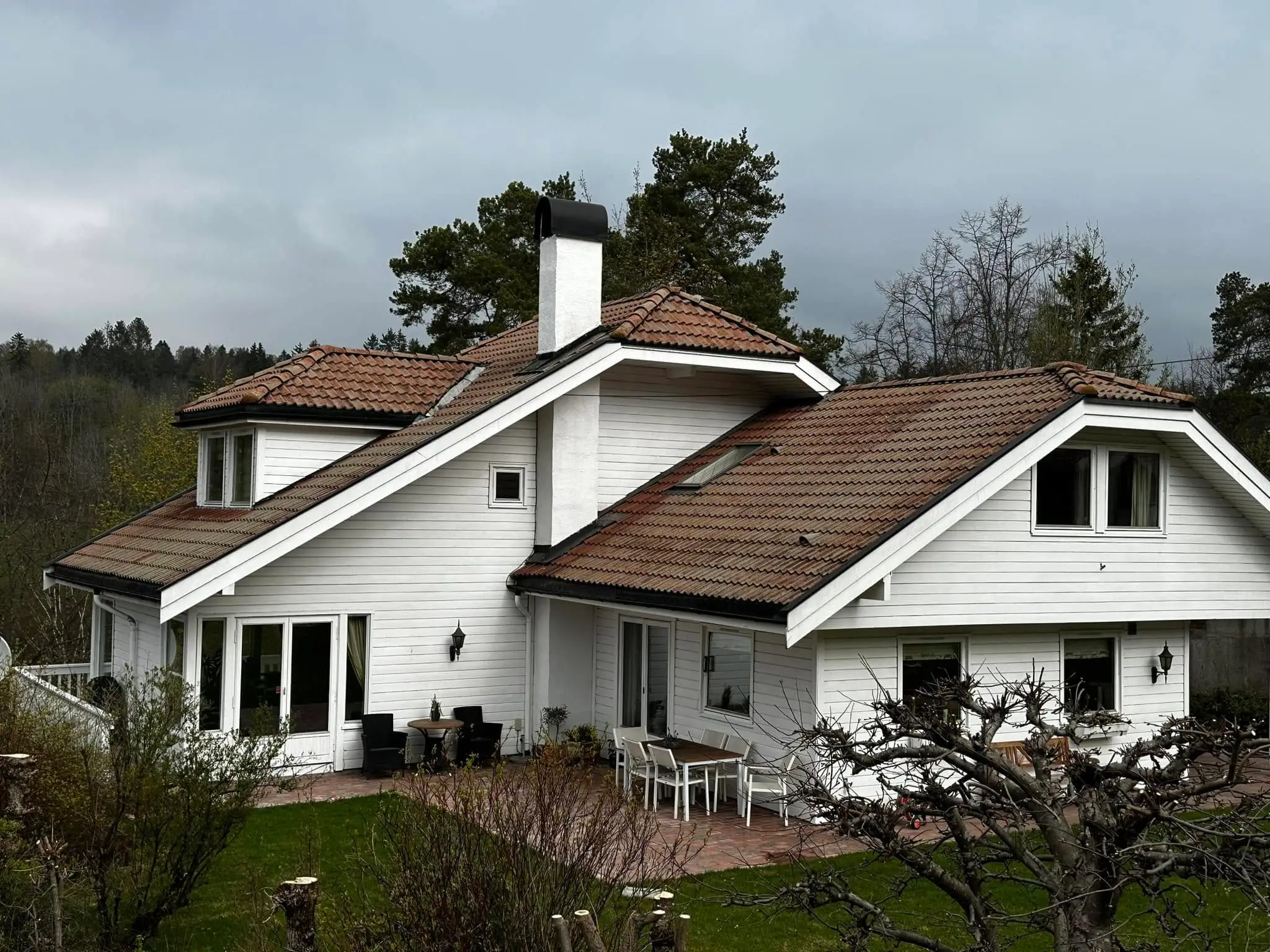 Enebolig med gammel, brun og mosegrodd betongtakstein før omlegging